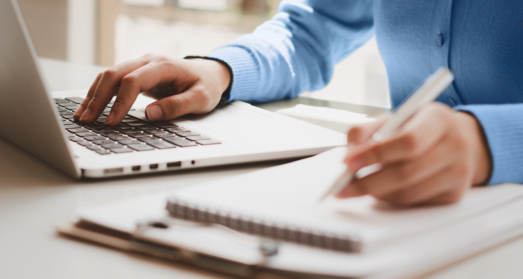 Person with notebook and laptop